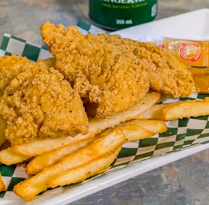 Golden breaded chicken tenders with fries on green and white checkered paper
