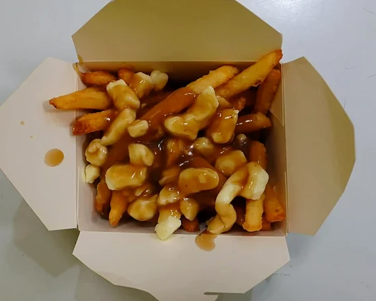 Classic poutine with fries, cheese curds and brown gravy in a takeout box