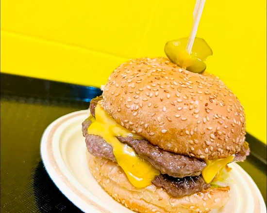 Double smash burger with two thin seared beef patties and melted American cheese on a sesame bun